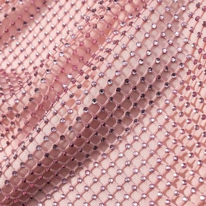 Macro shot of pink mesh fabric with sparkling rhinestones for sexy evening wear