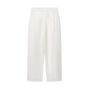 Detailed view of white wide-leg trousers featuring slim pleats and premium drape fabric