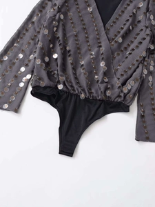 Detail of grey V-neck bodysuit showing shimmering silver and bronze sequins on the fabric