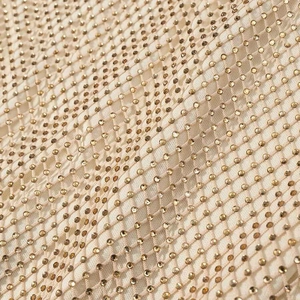 Vue macro détaillée du tissu en maille champagne avec des strass dorés scintillants