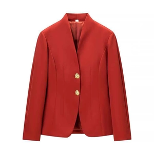 Detail of red blazer with deep V-neckline and decorative gold buttons on a white background