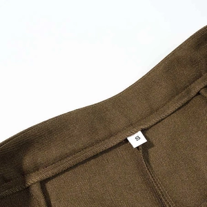 Macro detail of brown twill blazer waistline showing precise stitching and size S label