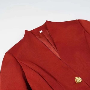 Macro detail of V-neck collar and unique gold metal button on red blazer jacket