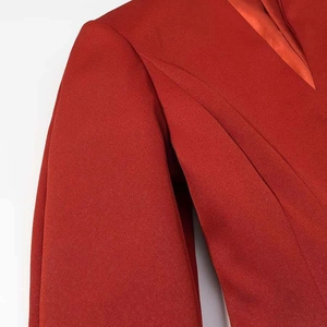 Detailed macro view of the deep red blazer jacket with elegant satin inner lining