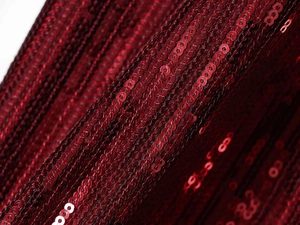 Makro-Detail von hochwertigen dunkelroten Pailletten in linearer Matrix auf Kleiderstoff