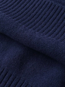 Close-up of deep blue rib-knit fabric texture showing fine craftsmanship and soft wool fibers
