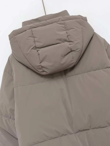 Dettaglio della giacca imbottita con cappuccio e trapuntatura orizzontale in taupe