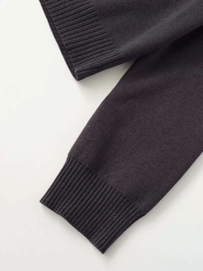 Detailed close-up of dark grey ribbed knit cuffs showing fine texture and stitching