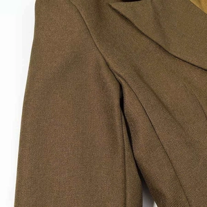 Detail shot of olive green blazer fabric showing fine twill texture and shoulder seam