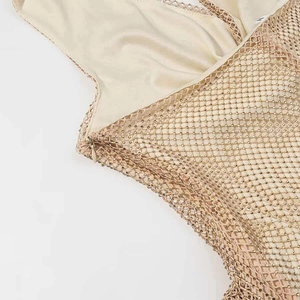Détail de la robe en résille dorée champagne avec fermeture éclair invisible et perles