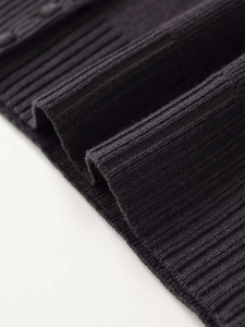 Macro detail of dark grey ribbed knit fabric showing high-quality texture and stitching