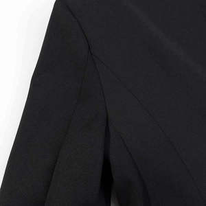 Detailed close-up showing the professional shoulder seam and twill fabric texture of the black blazer