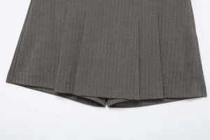 Detailed close-up showing the grey herringbone pattern fabric and pleated design of the skort