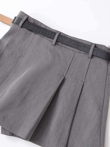 Detailed view of dark grey pleated mini skirt featuring a black faux crocodile skin belt