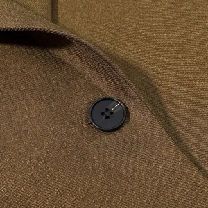 Detailed close-up of premium olive twill fabric and a classic four-hole button on the blazer