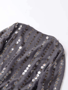 Detailed macro view of grey fabric featuring vertical rows of shiny colorful sequins