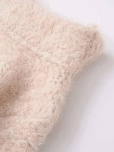 Detailed close-up of the soft plush mohair knit fabric texture in light beige pink color