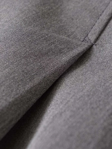 Detailed macro view showing the fine twill texture and neat stitching of dark grey fabric