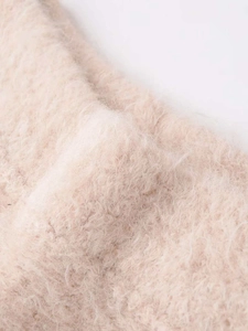 Detailed macro view of soft beige mohair knit fabric showing fluffy texture and fibers