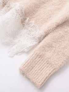 Close-up of fluffy knit sweater featuring delicate eyelash lace trim and ribbed cuffs