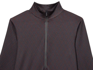 Detailed view of the dark red and navy geometric knit fabric with a half-zip stand collar