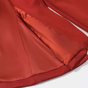 Detailed view of dark red blazer showing fine twill fabric and smooth satin lining