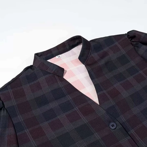 Dettaglio del colletto di una camicia scozzese vintage con scollo a V, bottone e taglia M