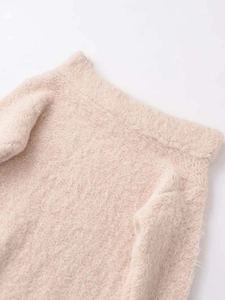 Close-up of pink fuzzy knit fabric with premium ribbed edges and soft texture
