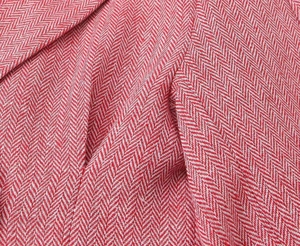 Dettaglio della trama a spina di pesce rosa e bianca su un tessuto classico per blazer