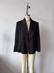 Detail showing the single-button closure and classic vertical stripes on black blazer