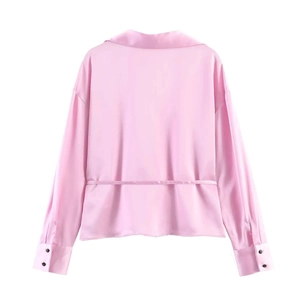 Detailed back view of light pink satin shirt featuring narrow waist ties and wide cuffs