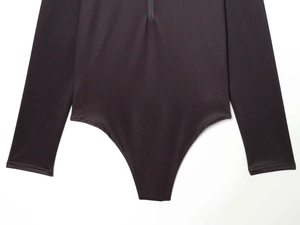 Close-up of slim fit bodysuit featuring dark vintage monogram pattern and zipper detail