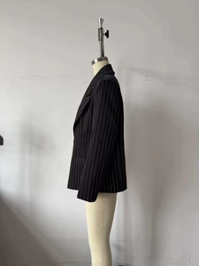 Detailed view of dark pinstripe blazer fabric and structured professional lapel design