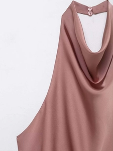 Détail du haut dos nu en satin rose avec col drapé élégant et fermeture à double bouton