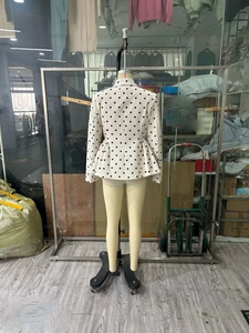 Detail view showing the back of a white polka dot peplum waist blazer for women
