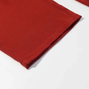 Detail shot of deep red suit trousers showing high-quality twill fabric and neat double stitching