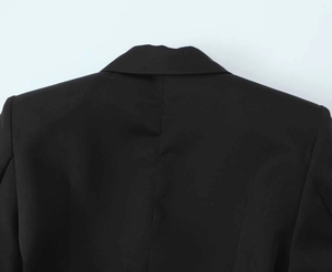 Macro view of the collar and shoulder tailoring on this black cropped blazer jacket