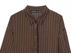 Macro detail of brown striped shirt collar with classic pointed lapel and brand label
