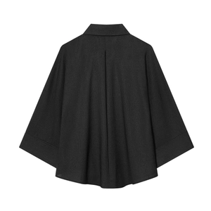 Rear view of black oversized batwing sleeve shirt featuring back pleat and refined texture