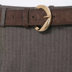 Deep brown suede belt featuring a vintage gold crescent buckle on herringbone trousers