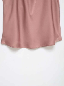 Détail du haut en satin vieux rose avec un ourlet arrondi lisse et couture de qualité