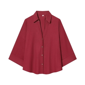 Detailed macro view of the textured burgundy fabric and V-neck collar on this summer shirt
