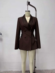 Detailed close-up of dark brown blazer featuring satin lapels and waist lace-up detail