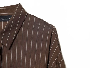 Detailed view of dark brown pinstripe shirt collar with clean stitching and size tag