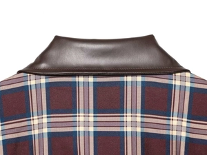 Gros plan du col en cuir marron et du tissu écossais rouge vintage avec couture précise