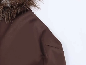 Close-up of brown halter dress featuring premium feather trim and glossy silk texture