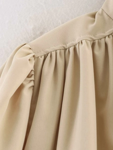 Detail shot showing the refined ruffled design and premium khaki fabric on a women's jacket
