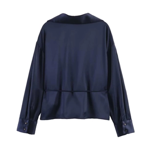 Detail view of the back of a navy blue satin shirt with smooth texture and seam detail