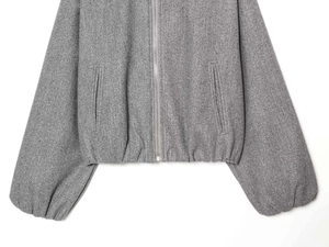 Detailed close-up of grey zip-up bomber jacket showing soft fabric texture and side pockets