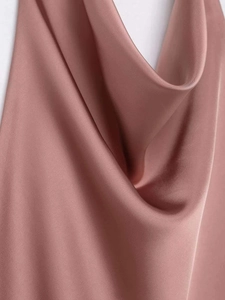 Gros plan sur le tissu en satin rose élégant avec des plis drapés doux sur un haut
